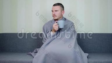 一个满身毯子的病人望着窗外，喝着一杯热茶